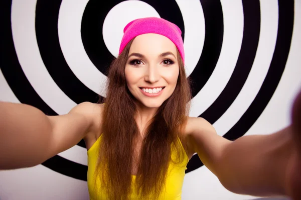 Gyönyörű lány sugárzó mosollyal a rózsaszín sapka, így selfie — Stock Fotó