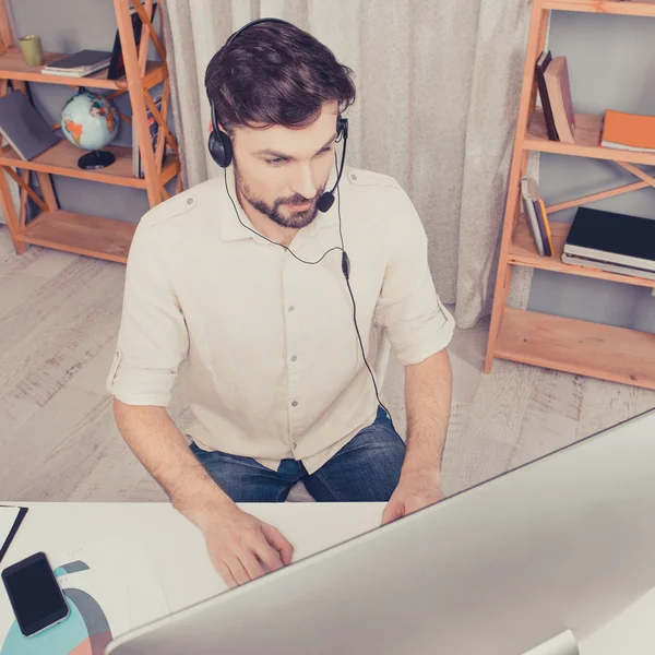 Retrato de joven trabajador feliz del centro de llamadas en los auriculares —  Fotos de Stock