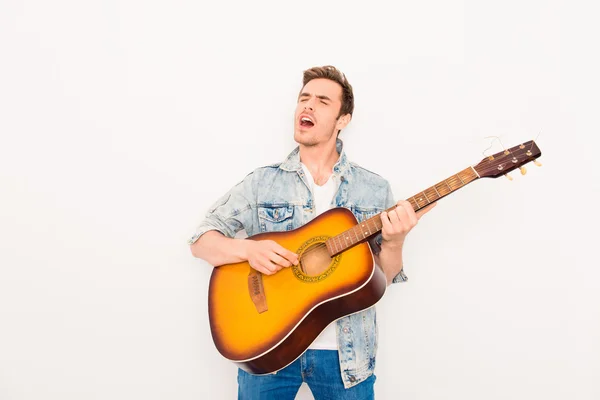 Jovem músico tocando guitarra e cantando em fundo branco — Fotografia de Stock