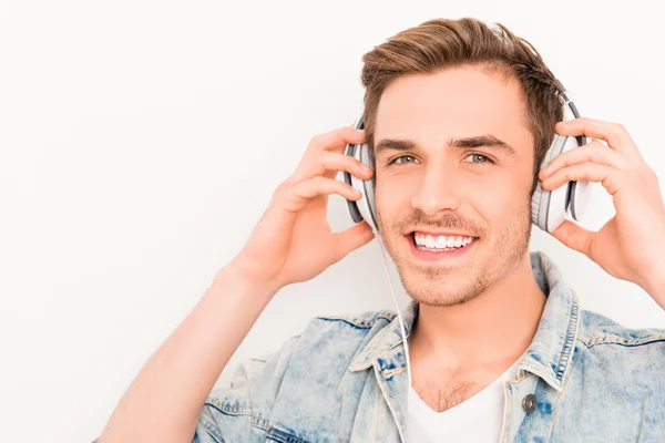 Портрет счастливого улыбающегося парня, слушающего музыку в наушниках — стоковое фото