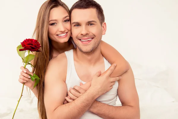 Hezká mladá žena držící růži a huging její přítel — Stock fotografie