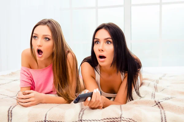 Scared pretty girls watching horror film with popcorn — Stock Photo, Image