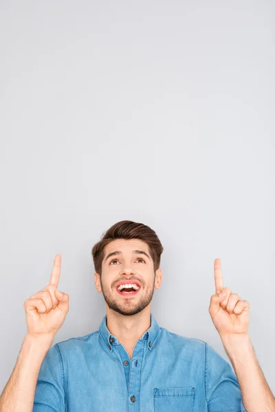Retrato de hombre sonriente alegre apuntando hacia arriba con los dedos —  Fotos de Stock