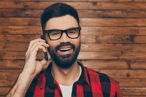 Allegro giovane uomo barbuto in spectakles parlando al telefono — Foto Stock