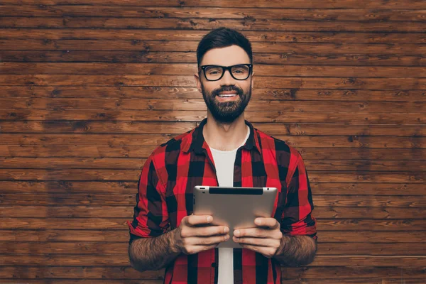 Красивый молодой бородатый мужчина в очках держит планшет — стоковое фото