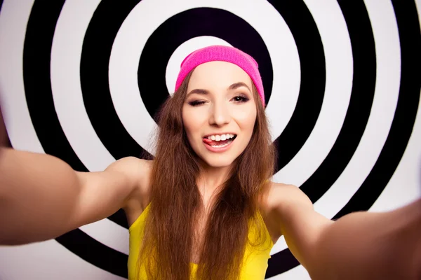 Κωμικό κορίτσι στο ροζ καπέλο κλείνει το μάτι και δείχνει την γλώσσας κάνοντας s — Φωτογραφία Αρχείου