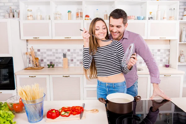 Portret van een leuk paar verliefd koelen van de warme maaltijd in de keuken — Stockfoto