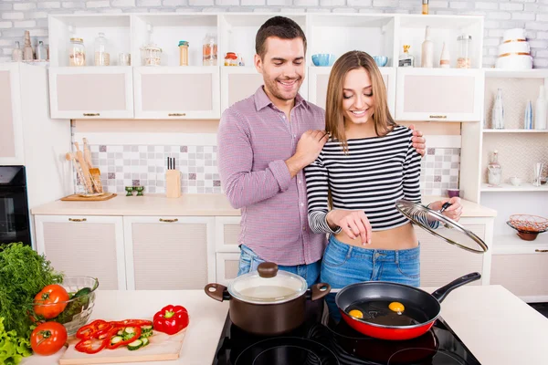 Lyckliga älskande par matlagning i köket och salt omelett — Stockfoto