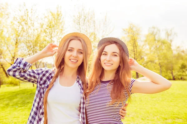 Portrait of two beautiful women in hats walking in the park — Stock Photo, Image