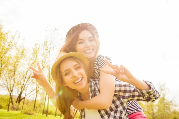 Счастливая улыбающаяся девочка, обнимающая своих сестер и жестикулирующая футболкой — стоковое фото