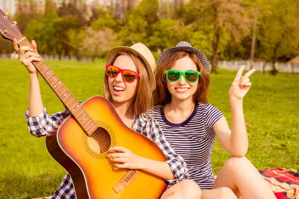 Cheerful happy girls having picnic and playing on guitar — Stock Photo, Image