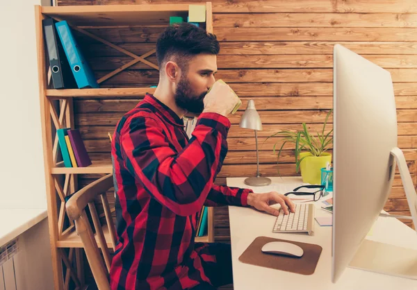 Joven hombre de negocios beber café mientras trabaja en PC —  Fotos de Stock