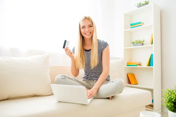 Feliz joven mostrando tarjeta de crédito y haciendo compras por internet — Foto de Stock