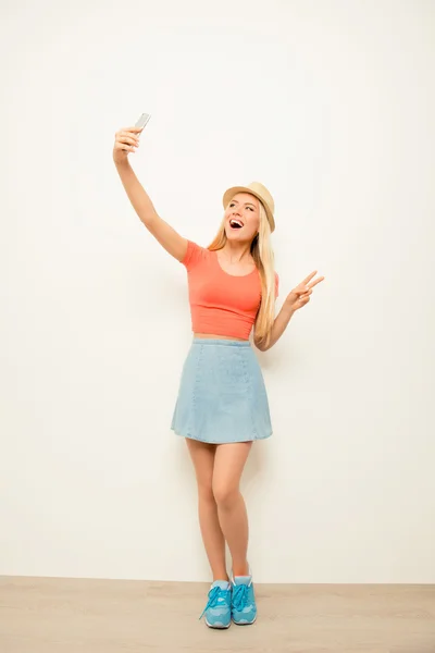 Vollständiges Porträt eines fröhlichen Mädchens mit Mütze, das Selfie macht — Stockfoto