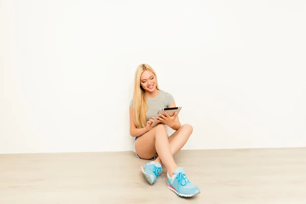 태블릿을 사용 하 고 바닥에 앉아 행복 한 어린 소녀 — 스톡 사진