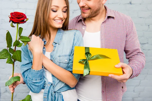 Молодий чоловік дарує червону троянду і подарунок своїй дівчині — стокове фото