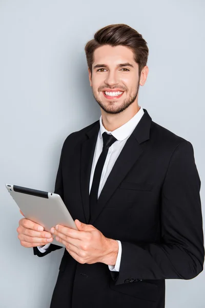 Счастливый успешный молодой бизнесмен держит цифровой планшет — стоковое фото