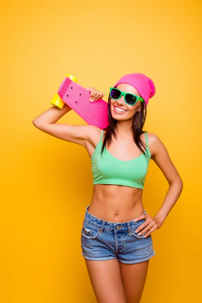 Portret van aantrekkelijke jonge hipster vrouw met roze longboar — Stockfoto
