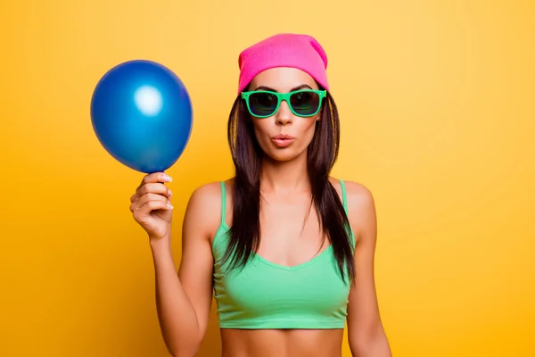 Vrolijke hipster meisje in roze hoed houden de ballon op gele wal — Stockfoto