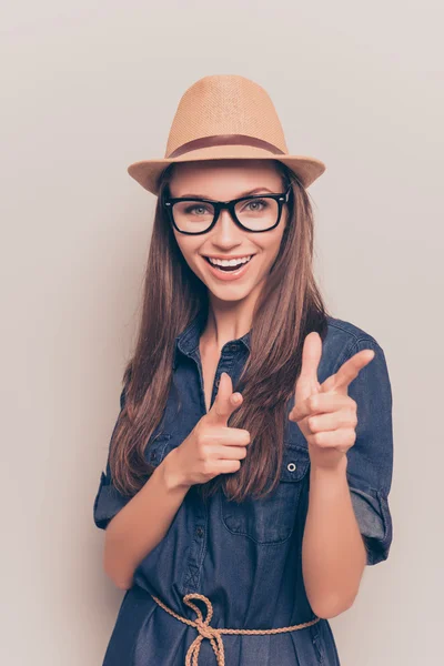 Chica bonita alegre en sombrero y gafas apuntando a la cámara —  Fotos de Stock