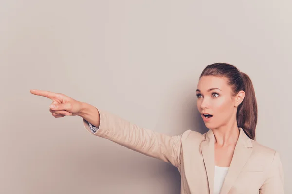 Mooie jonge zakenvrouw wijzen met de vinger weg verrast — Stockfoto