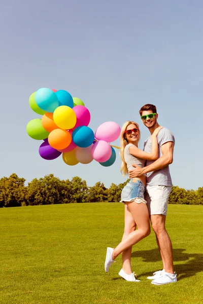 Retrato de jovem família encantadora feliz com balões com mel — Fotografia de Stock