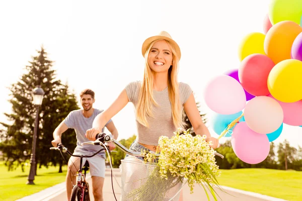 Hübsches lächelndes Mädchen, das mit ihrem Freund Fahrrad fährt — Stockfoto