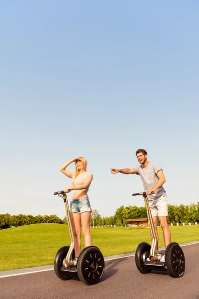 Homme heureux et femme équitation segway et à la recherche de façon — Photo