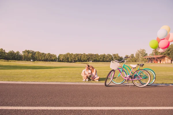 Couple romantique amoureux de bicyclettes reposant sur l'herbe — Photo