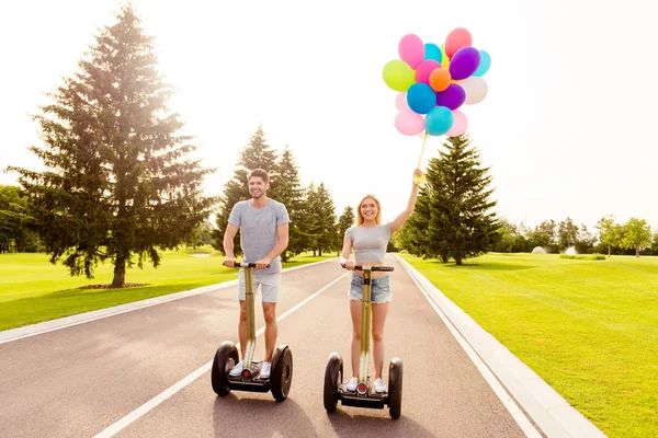 Hombre y mujer teniendo vacaciones románticas de verano y paseos en segways —  Fotos de Stock