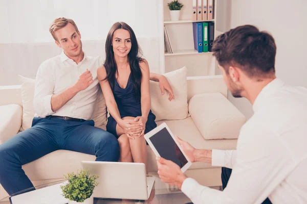 Jonge gelukkige paar tijdens bijeenkomst met agent — Stockfoto