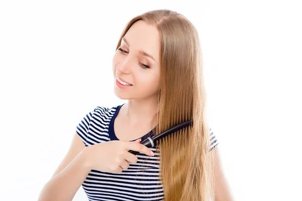 Feliz linda chica peinando su largo cabello rubio sano — Foto de Stock