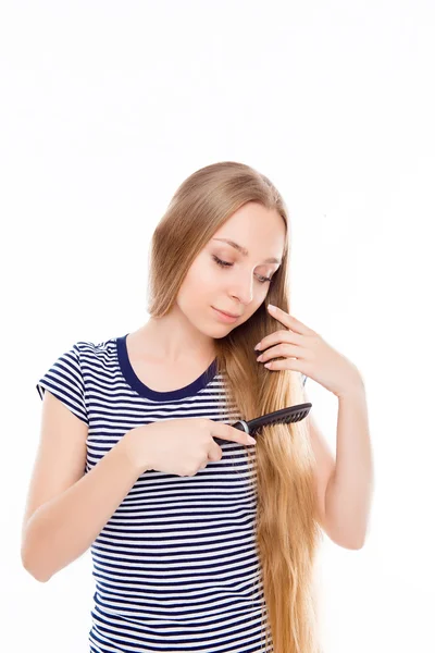 Menina feliz penteando seu cabelo longo — Fotografia de Stock