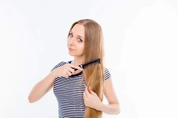 Feliz linda chica peinando su largo cabello rubio sano — Foto de Stock