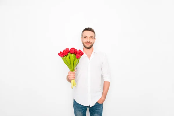 Красивий чоловік тримає букет тюльпанів на білому тлі — стокове фото