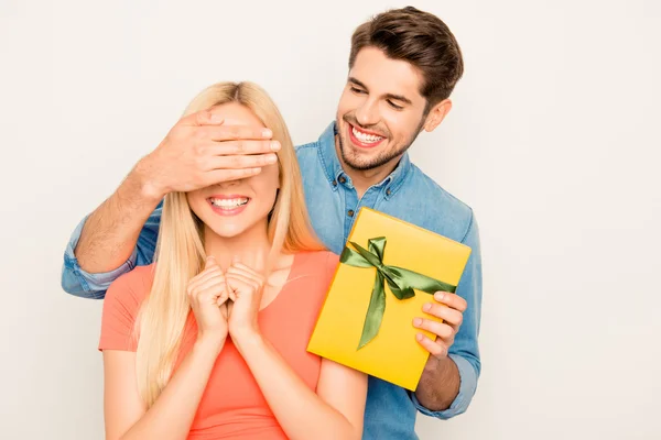 Feliz hombre cerrando los ojos de su esposa y sosteniendo presente — Foto de Stock