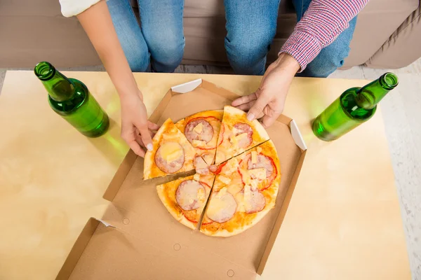 ビールとピザを食べる男女のトップ ビュー — ストック写真