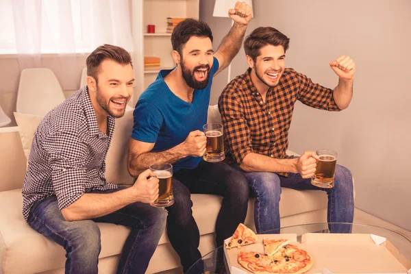 Фото счастливых веселых мужчин, держащих стакан пива и смотрящих — стоковое фото