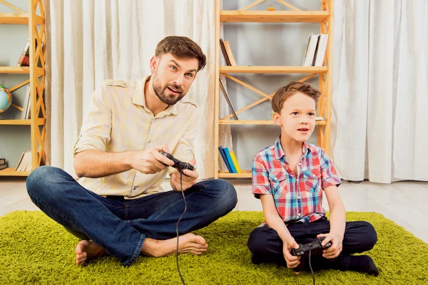 Padre y su hijito jugando videojuegos — Foto de Stock
