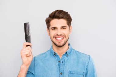 Happy guy with beaming smile and healthy hair holding comb clipart