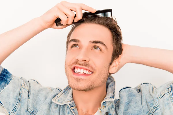 Portrait of handsome young guy combing his hair — Stock Photo, Image
