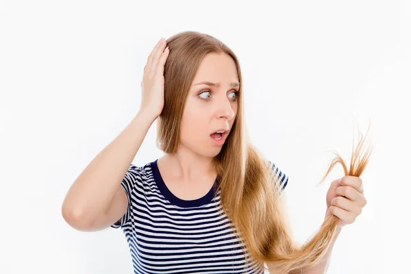Triste menina chocada olhando para seu cabelo danificado — Fotografia de Stock