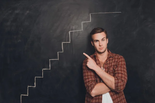Портрет успешного молодого человека, указывающего на нарисованную лестницу — стоковое фото