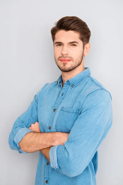 Portrait of calm handsome young brunet with crossed hands — Stock Photo, Image