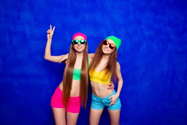 Trendy hipster girls wear colorful shorts, hat and glasses smili — Stock Photo, Image