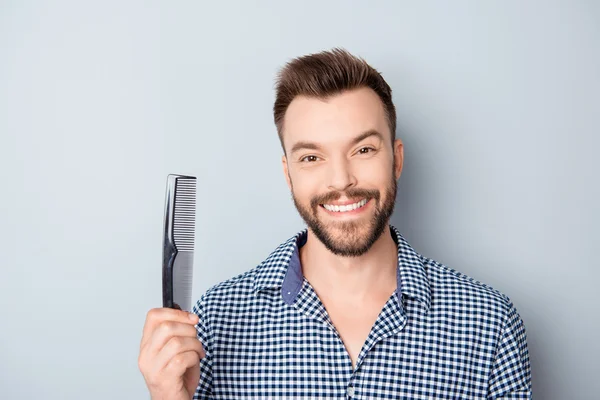 Chico feliz con sonrisa radiante y cabello sano sosteniendo peine —  Fotos de Stock