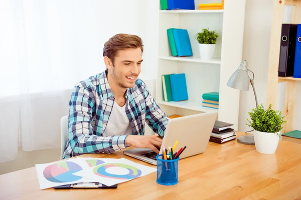 Porträt eines glücklichen jungen Mannes, der mit Laptop arbeitet — Stockfoto