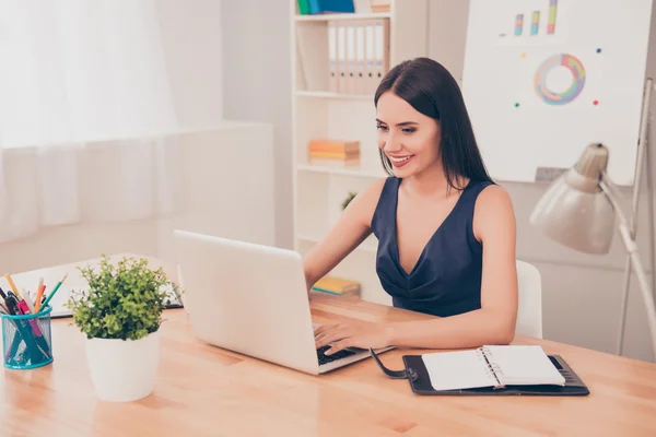 Sonriendo joven mujer de negocios inteligente en el trabajo en la oficina con regazo — Foto de Stock