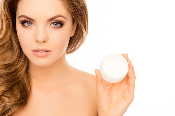 Retrato de mujer bonita sosteniendo tarro de crema para la cara — Foto de Stock