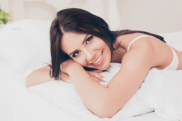 Retrato de una mujer joven y bonita acostada en la cama después del sueño — Foto de Stock